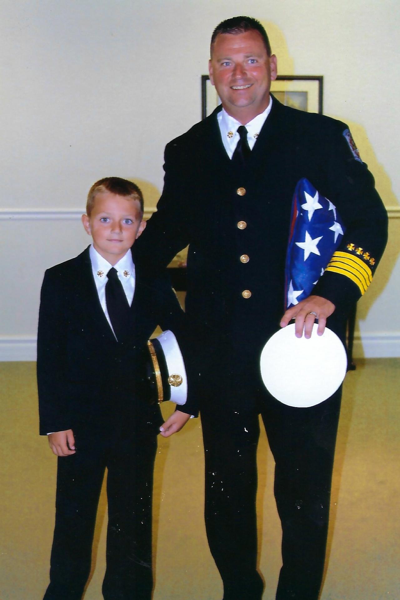 Barry Alexander with his father in fire department dress uniforms